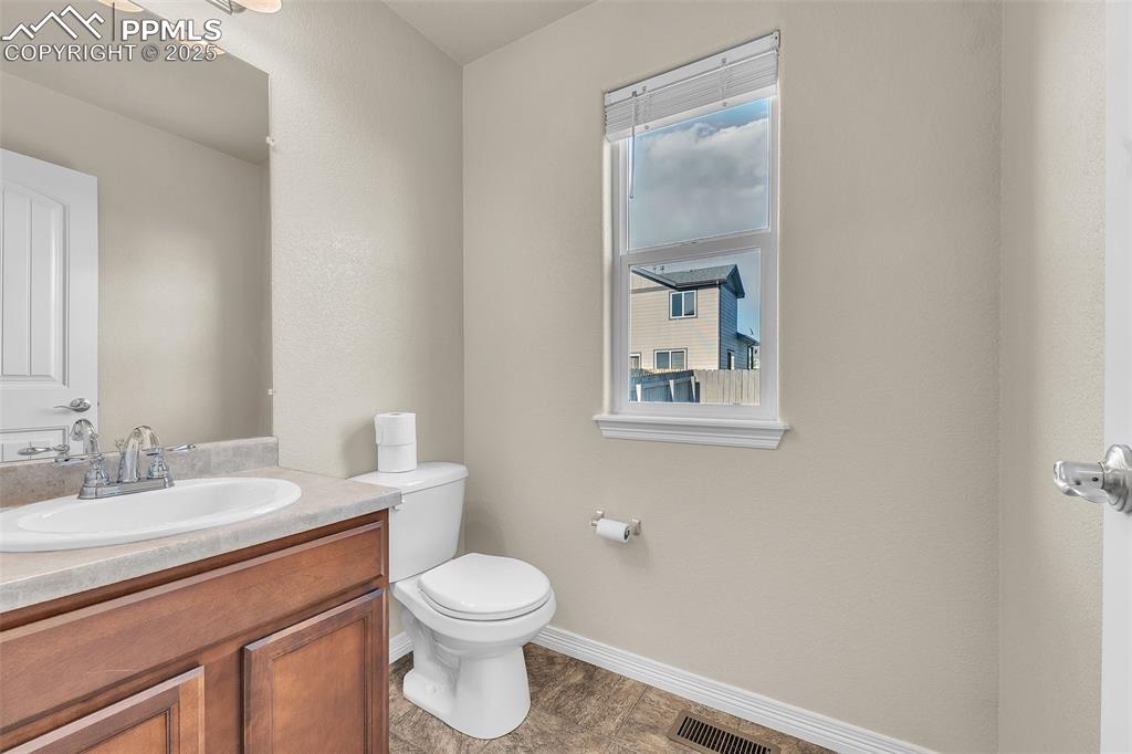 Image 15 of 28: Half bath with vanity and healthy amount of natural light