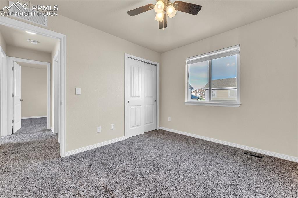 Image 17 of 28: Unfurnished bedroom with carpet, a closet, and a ceiling fan