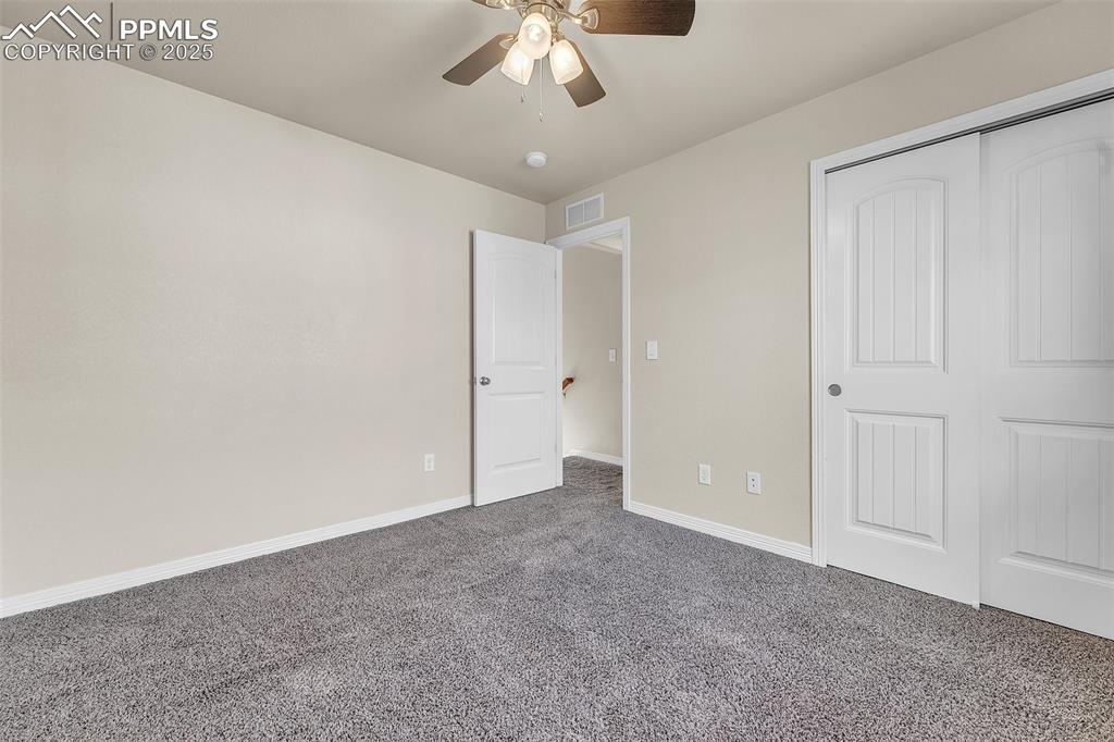 Image 18 of 28: Unfurnished bedroom with carpet flooring, ceiling fan, and a closet