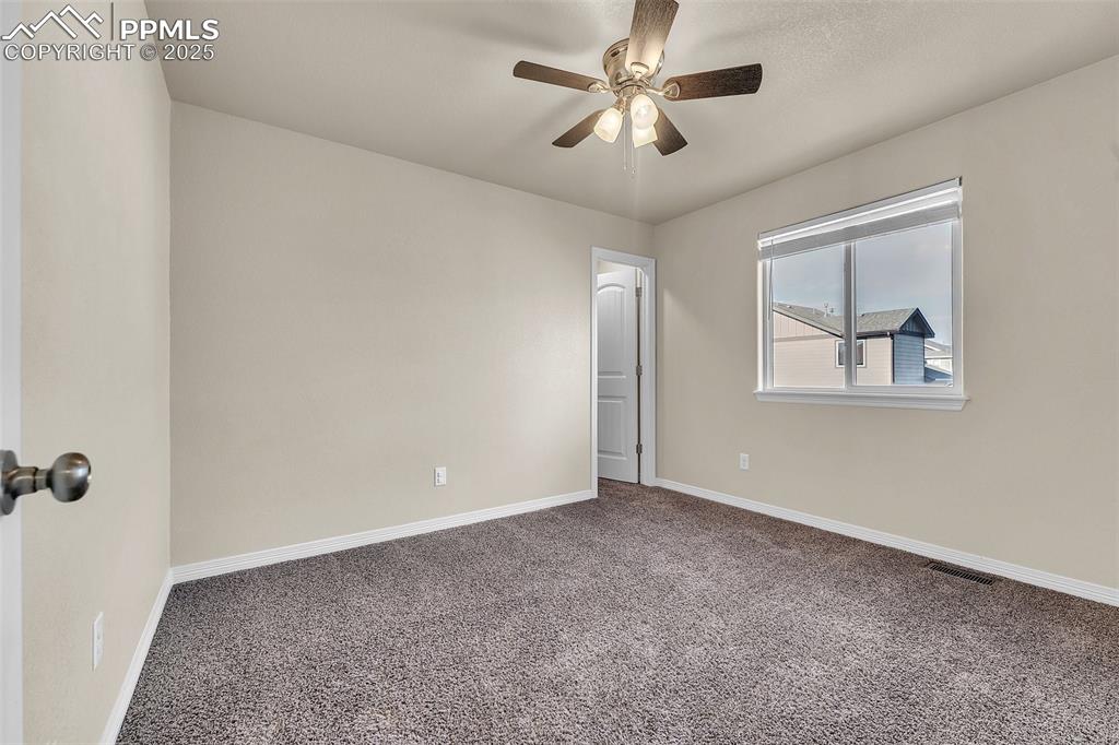 Image 24 of 28: Empty room featuring carpet floors and ceiling fan