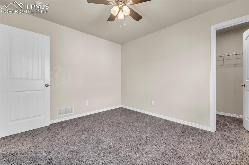 Image 25 of 28: Unfurnished bedroom featuring carpet floors, a spacious closet, and ceiling