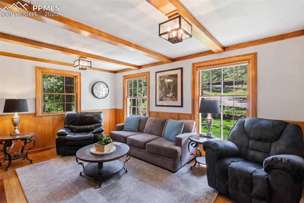Image 17 of 50: Living area featuring a wainscoted walls, plenty of natural light, beamed c