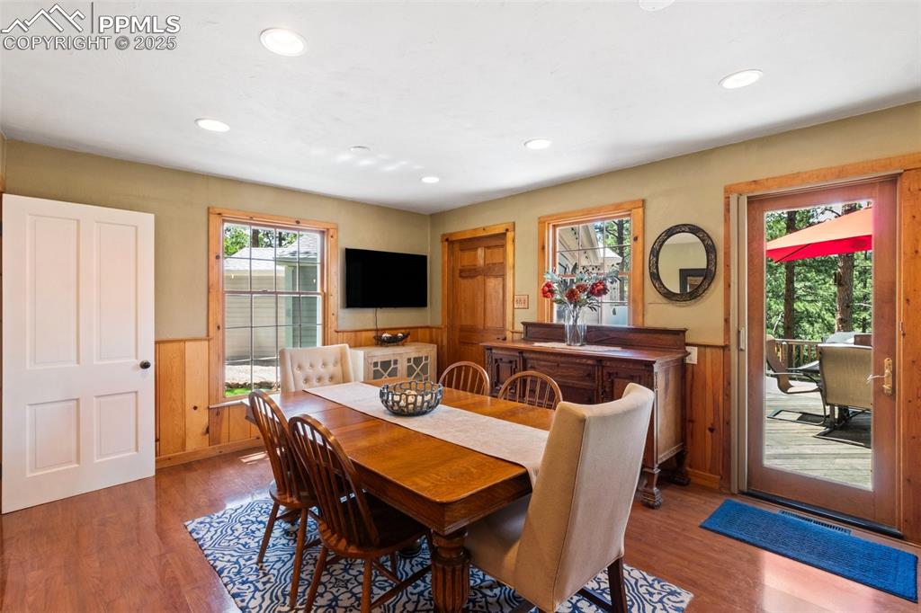 Image 22 of 50: Dining room featuring wainscoting, wood floors, and recessed lighting