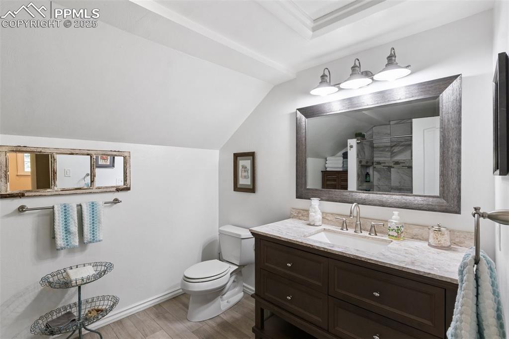 Image 36 of 50: Bathroom featuring vanity, lofted ceiling, and tiled shower