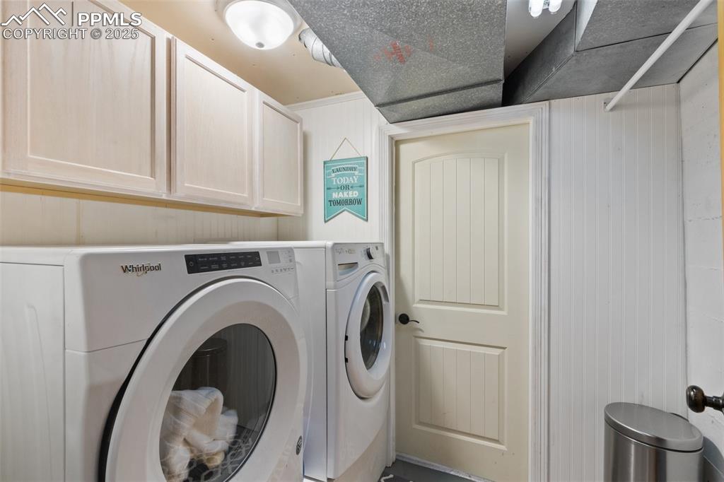 Image 44 of 50: Washroom with cabinet space and washing machine and clothes dryer