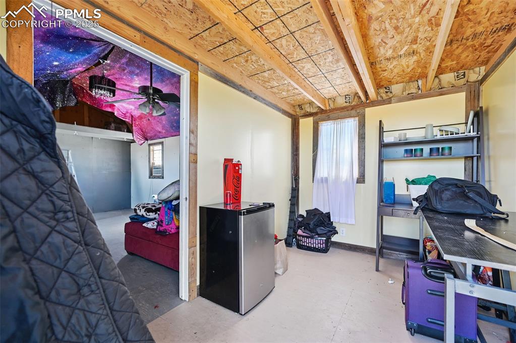 Image 12 of 48: Basement with freestanding refrigerator and a ceiling fan