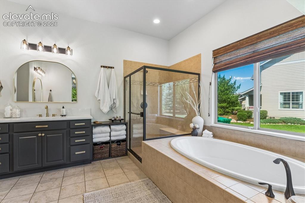 Image 22 of 50: Soaking tub and large walk-in shower in primary bathroom