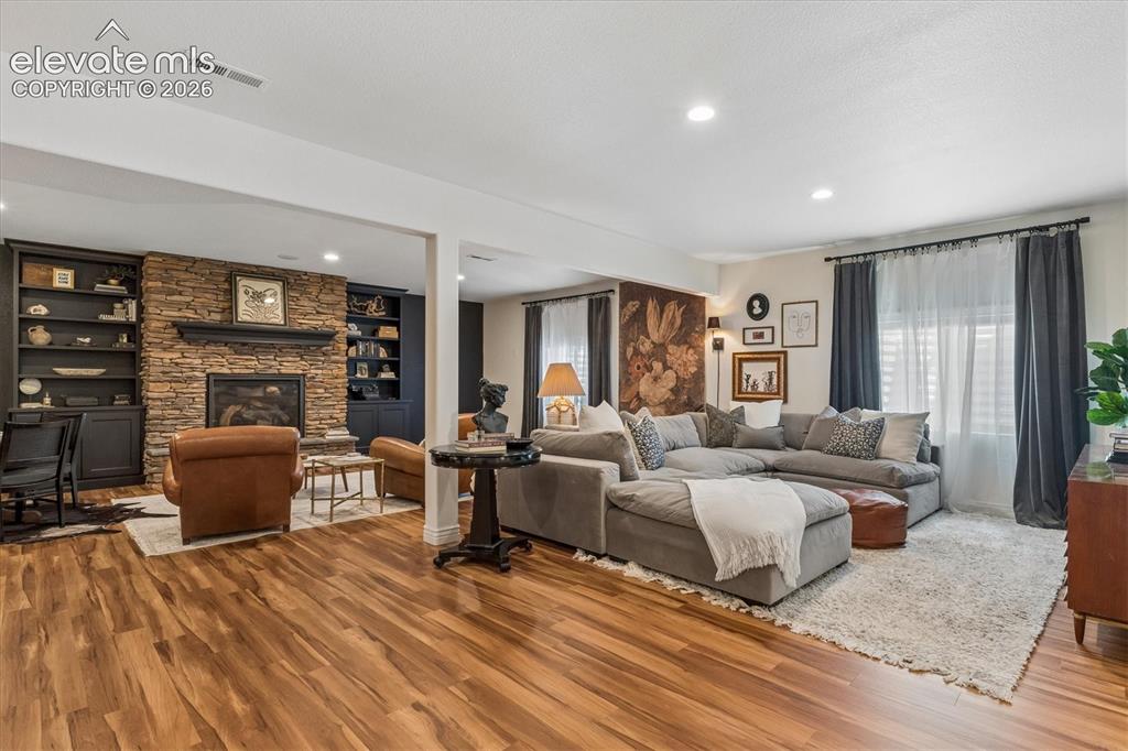 Image 27 of 50: Spacious living area featuring wood-finish flooring, recessed lighting, and