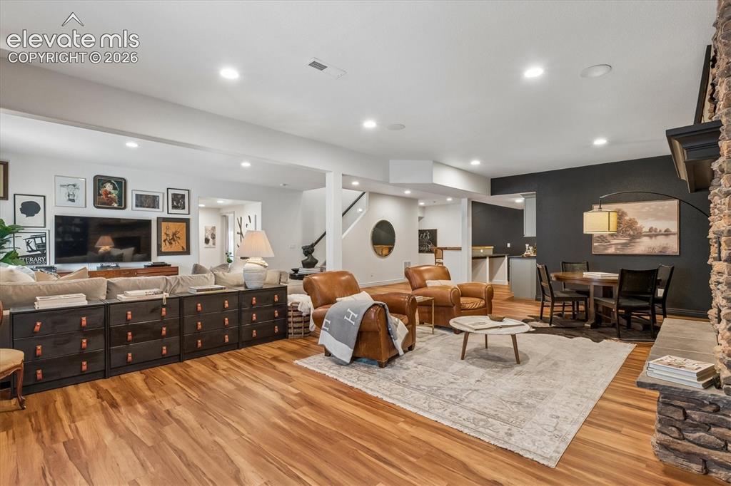 Image 29 of 50: Spacious living area featuring wood-finish flooring, recessed lighting, and