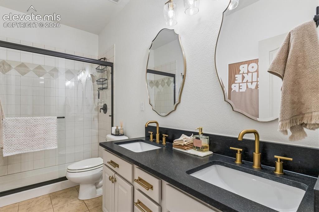 Image 37 of 50: Dual vanity with undermount sinks and dark countertop