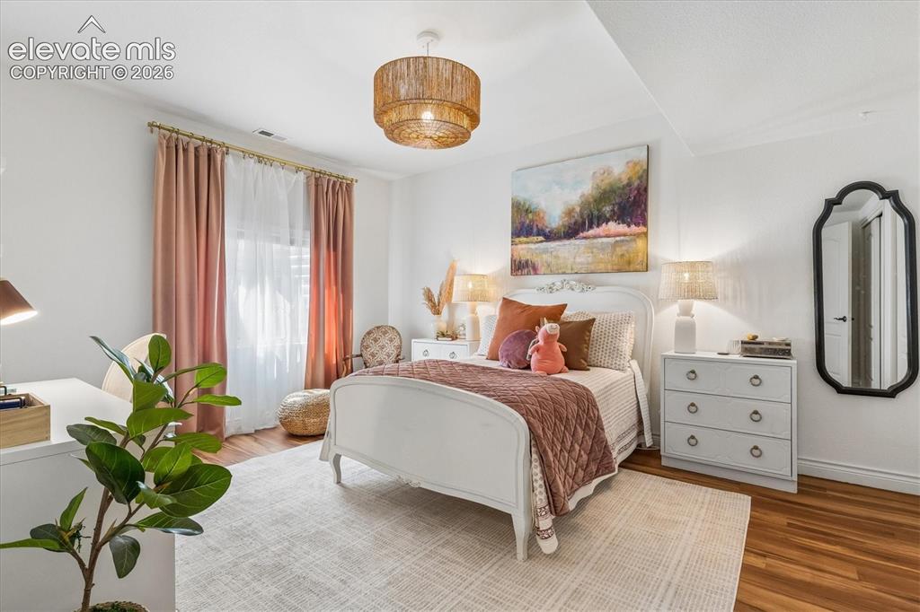 Image 38 of 50: Bright room featuring wood-finish flooring, a contemporary ceiling light fi