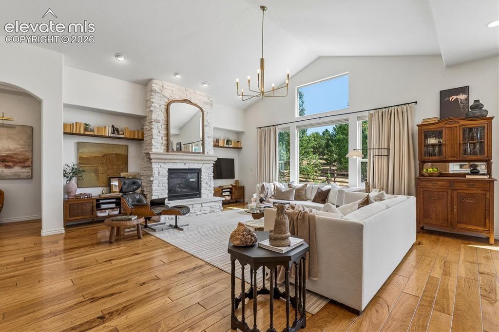 Image 4 of 50: Spacious living area featuring a floor-to-ceiling stacked stone fireplace
