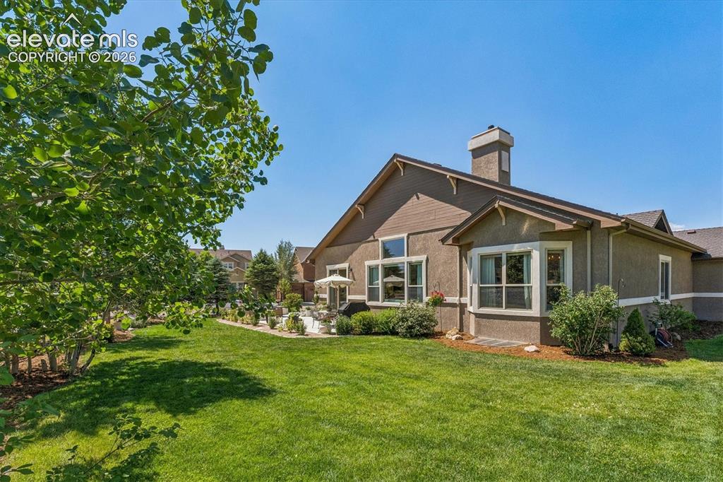 Image 42 of 50: Expansive green lawn with mature trees and professional landscaping