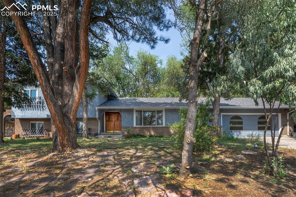 Caption: Split level home with brick siding and roof with shingles