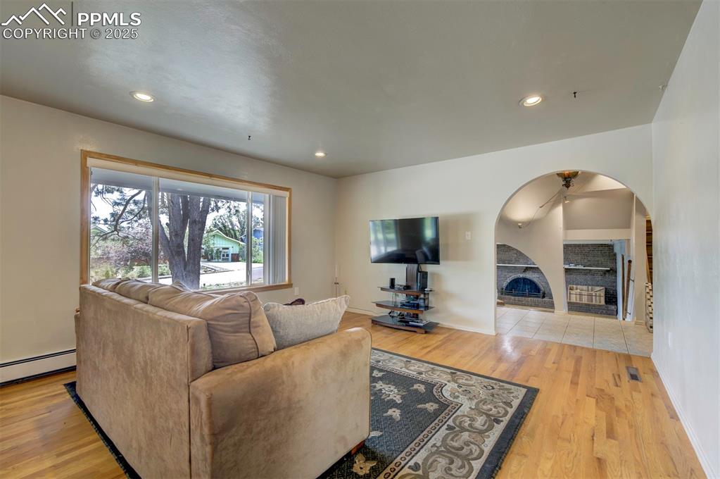 Image 11 of 44: Living area with light wood finished floors, recessed lighting, a fireplace
