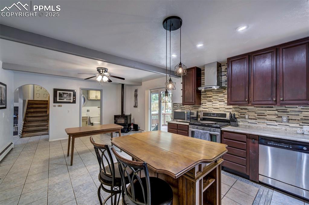 Image 15 of 44: Kitchen featuring appliances with stainless steel finishes, hanging light f