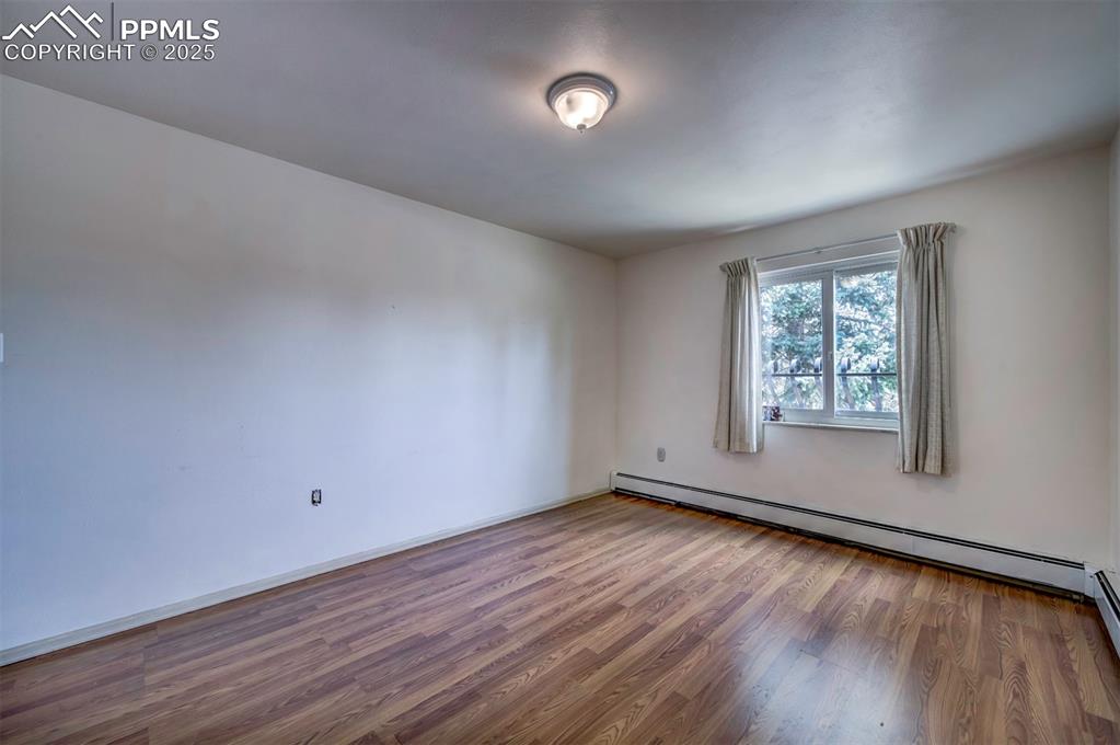 Image 30 of 44: Spare room featuring light wood-style flooring and baseboard heating