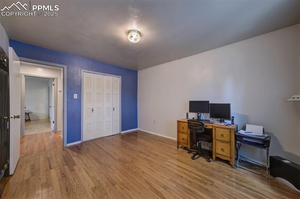 Image 32 of 44: Office space featuring wood finished floors and baseboards