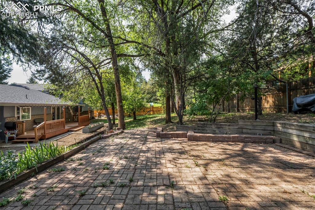 Image 35 of 44: Fenced backyard featuring a deck and a patio area