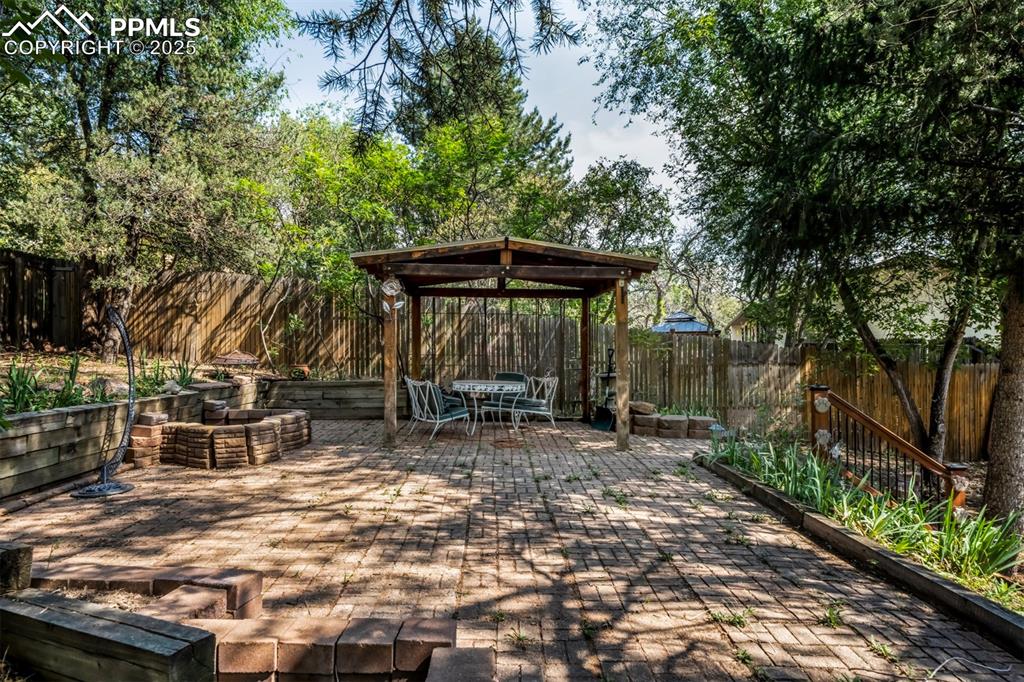 Image 36 of 44: Wooden terrace with a fenced backyard, a patio, and outdoor dining space