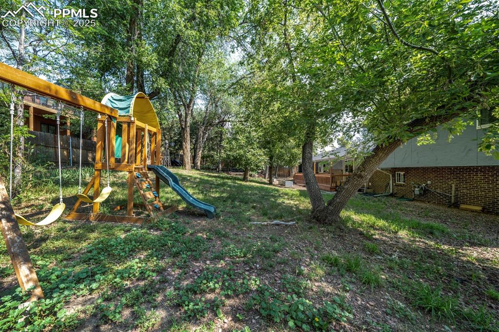 Image 37 of 44: View of jungle gym featuring a deck
