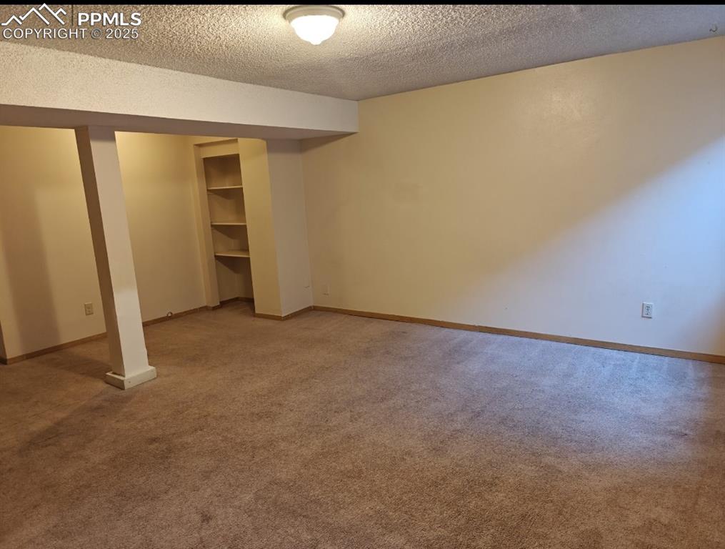 Image 13 of 17: Unfurnished bedroom featuring a textured ceiling, light carpet, and a close