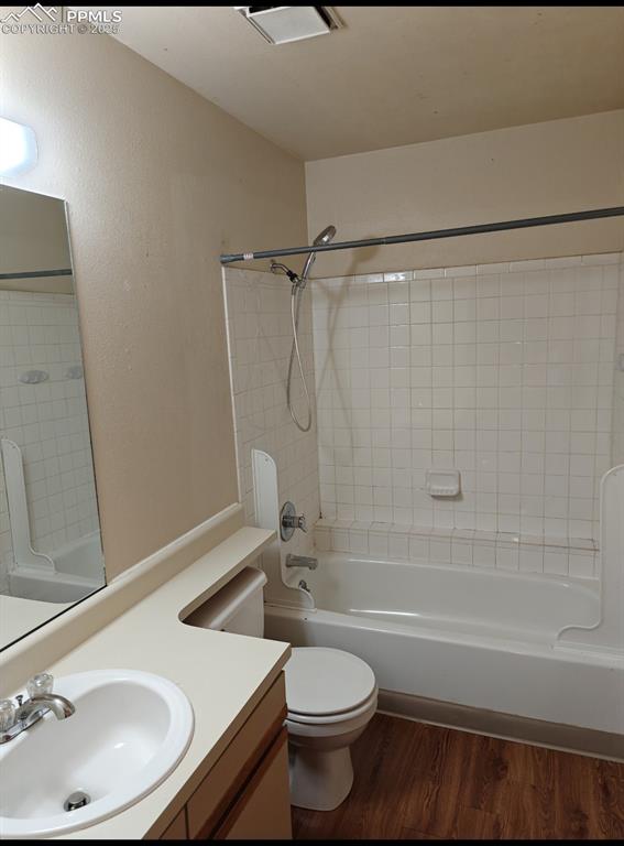 Image 14 of 17: Bathroom featuring wood finished floors, vanity, shower / washtub combinati