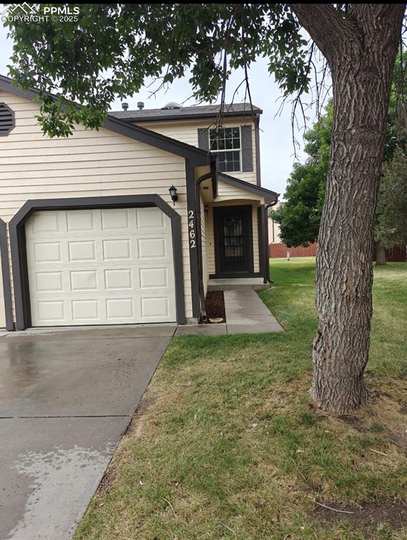 Image 2 of 17: Traditional-style home with concrete driveway, a front yard, and a garage