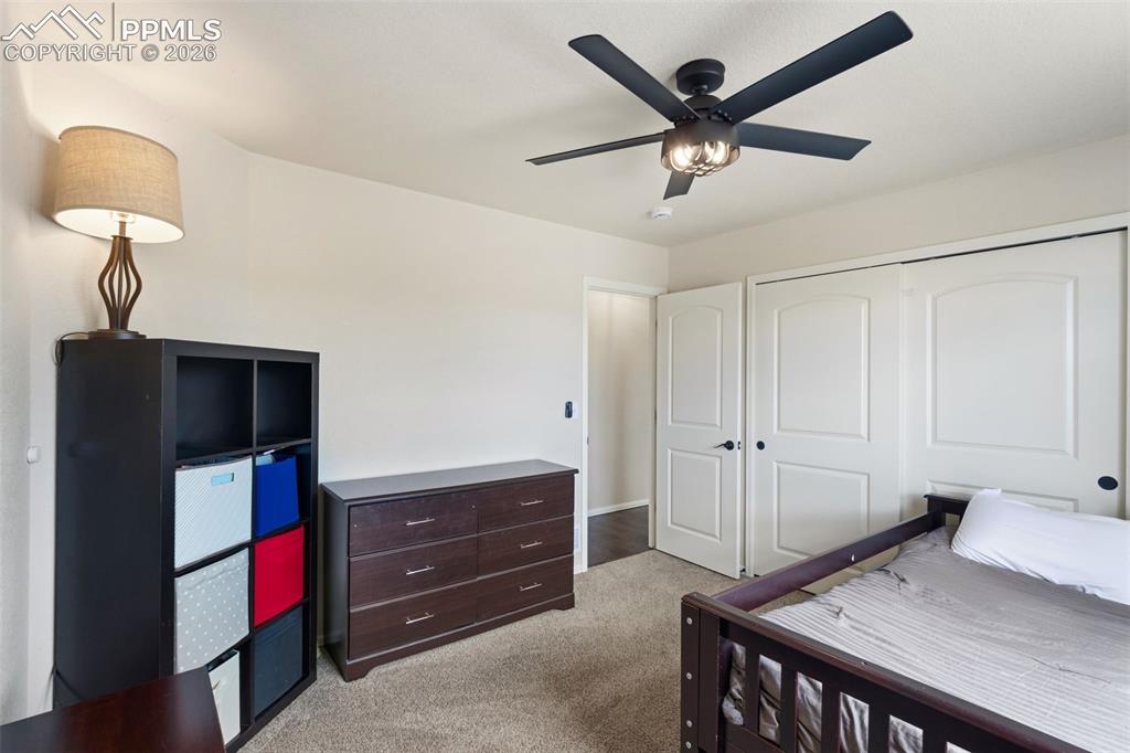 Image 17 of 32: Carpeted room featuring a ceiling fan with integrated lighting, a large win