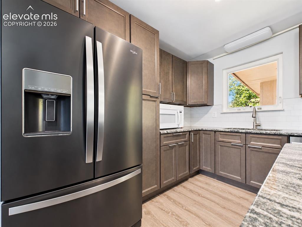 Image 14 of 50: Ample cabinetry surrounds the French-door refrigerator and microwave area, 