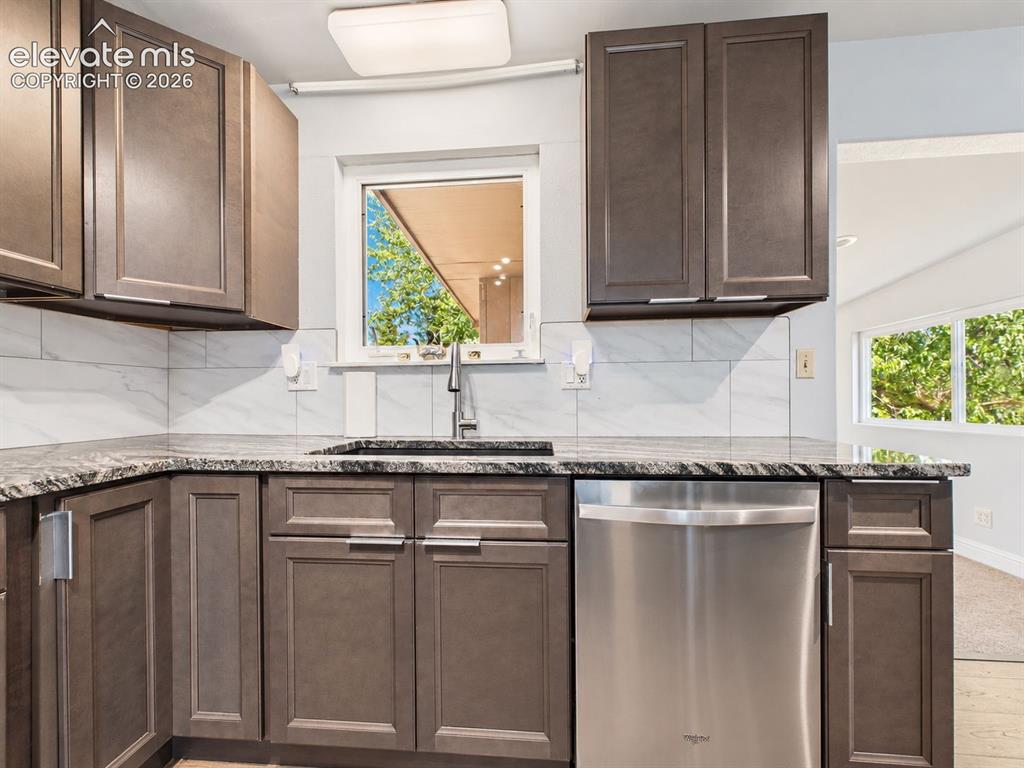 Image 15 of 50: Sink-side view showcases abundant cabinetry, stainless steel dishwasher, ti