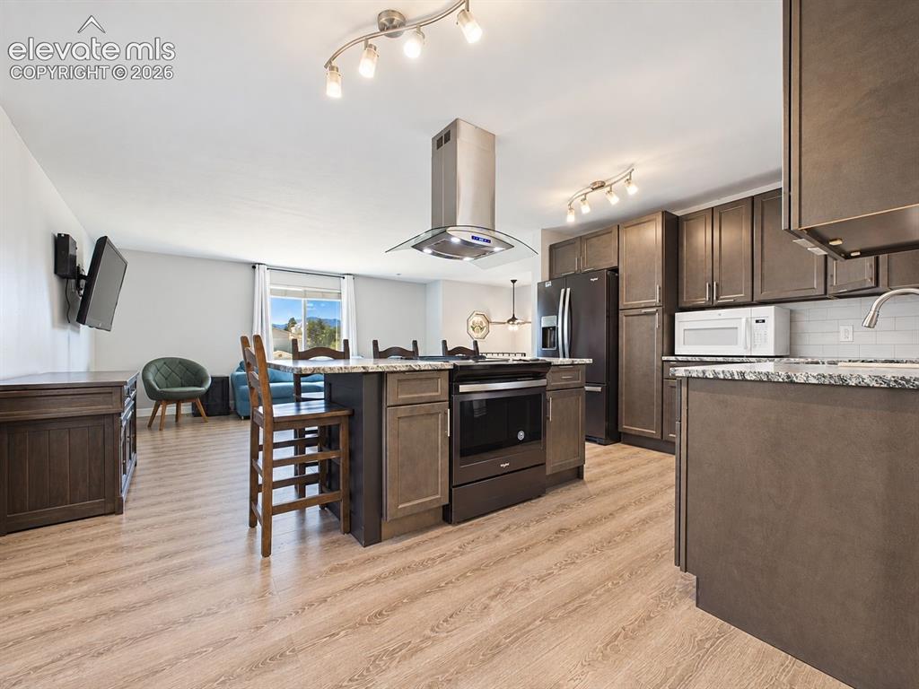 Image 17 of 50: Spacious remodeled kitchen pairs dark cabinetry with contrasting countertop