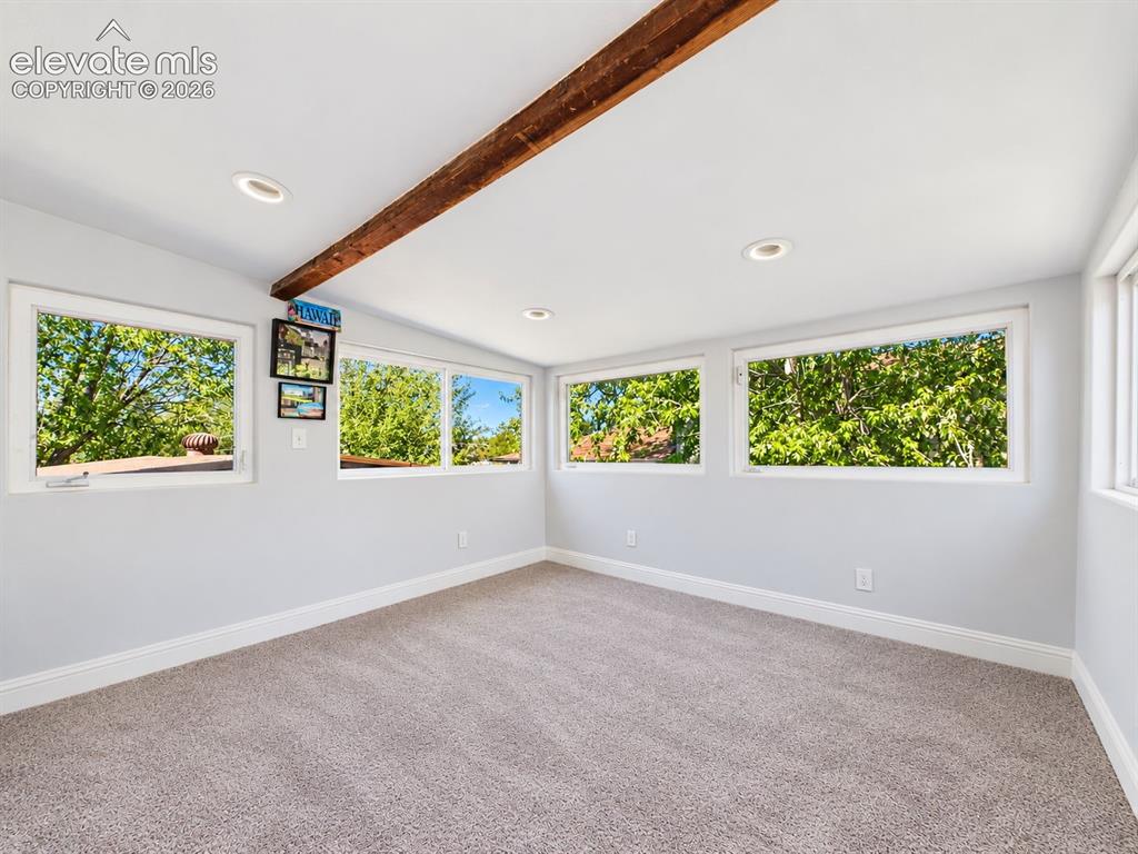 Image 19 of 50: Walls of windows fill this flexible bonus space with natural light and leaf