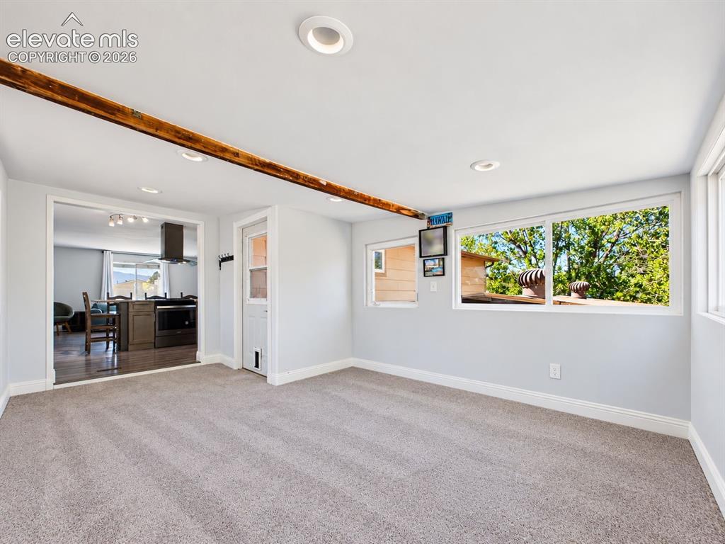 Image 20 of 50: Sunroom addition directly off the kitchen features soft carpeting, recessed