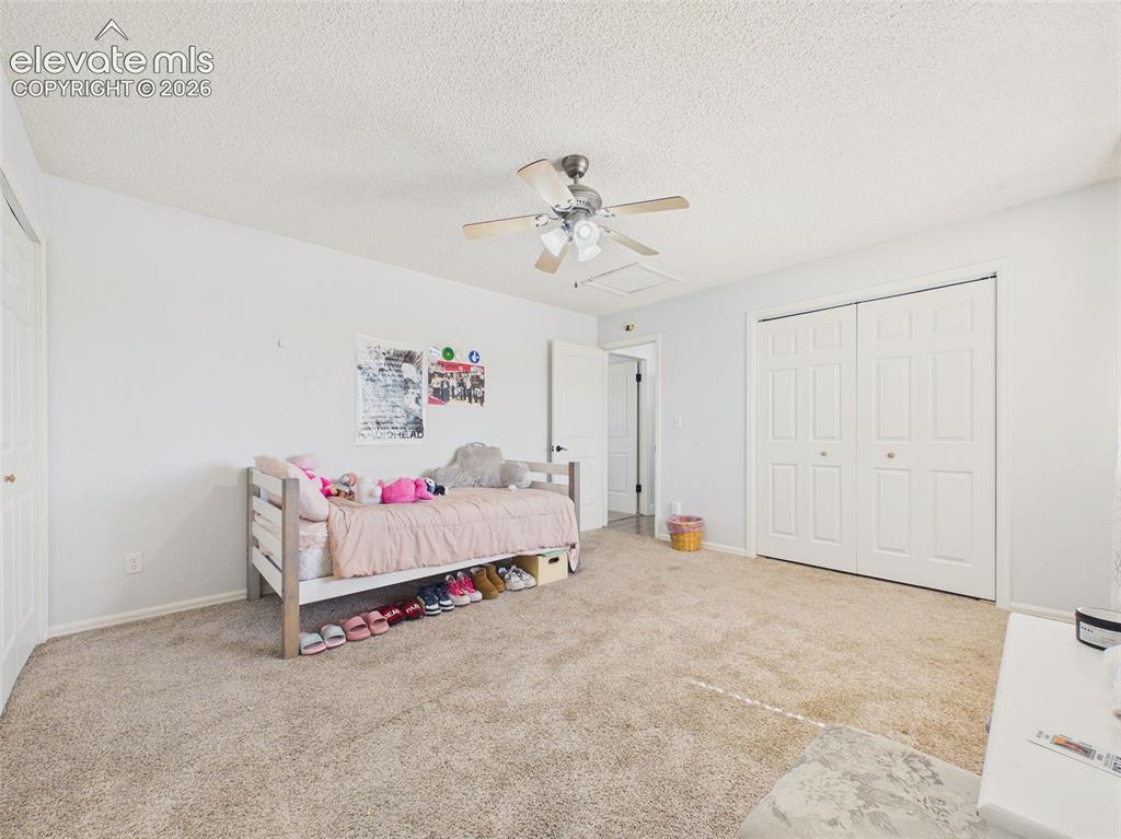 Image 24 of 50: Spacious secondary bedroom provides comfortable carpeting, a ceiling fan, a