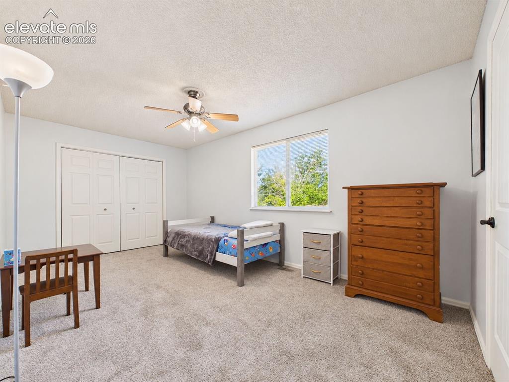 Image 26 of 50: Generously sized bedroom offers carpeting, a ceiling fan, a large window, a