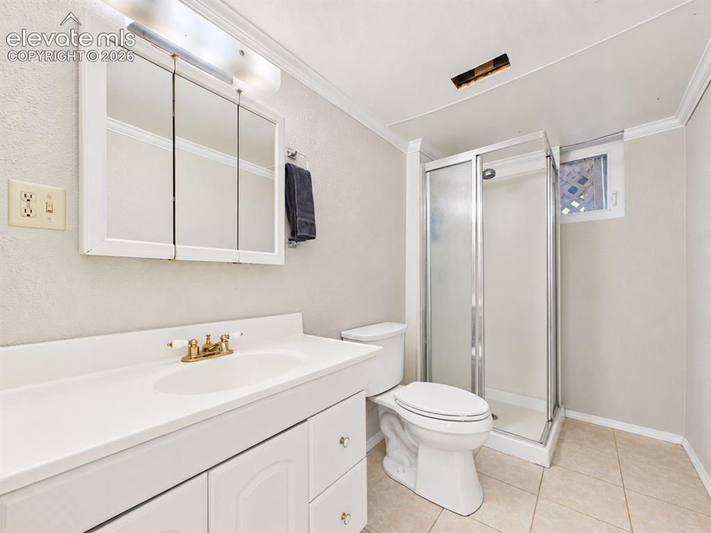 Image 33 of 50: 3/4 bathroom features a walk-in shower with glass enclosure, white vanity, 