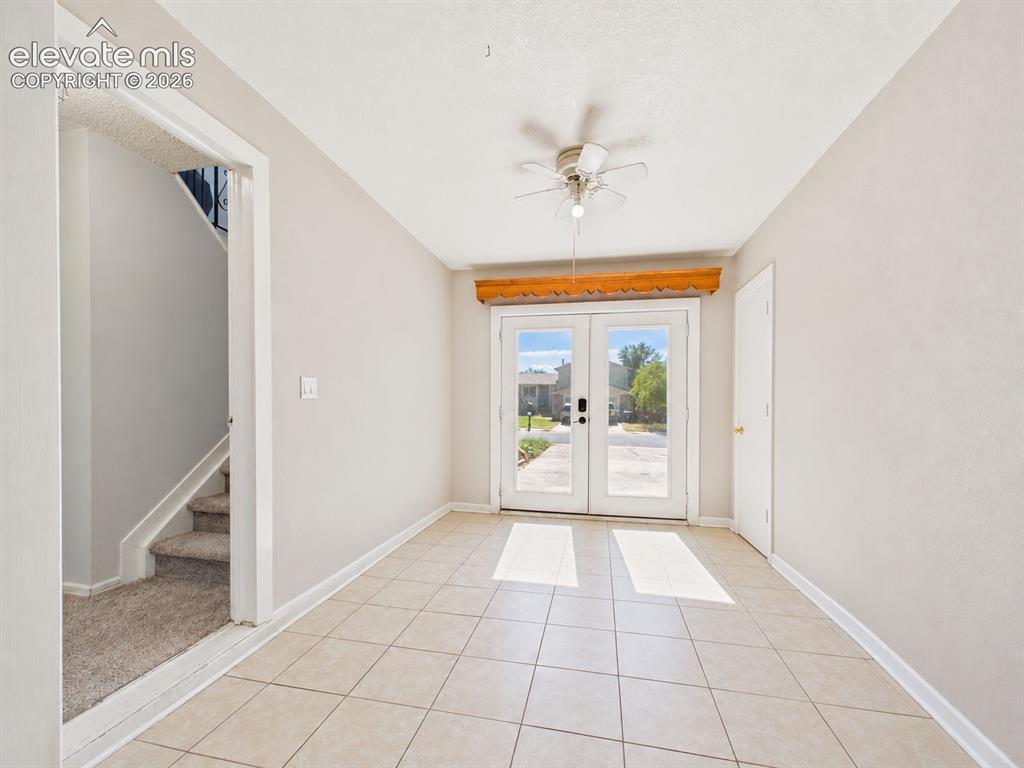 Image 34 of 50: Front Entry / Flex Space – Bright tiled entry area features glass-paneled d