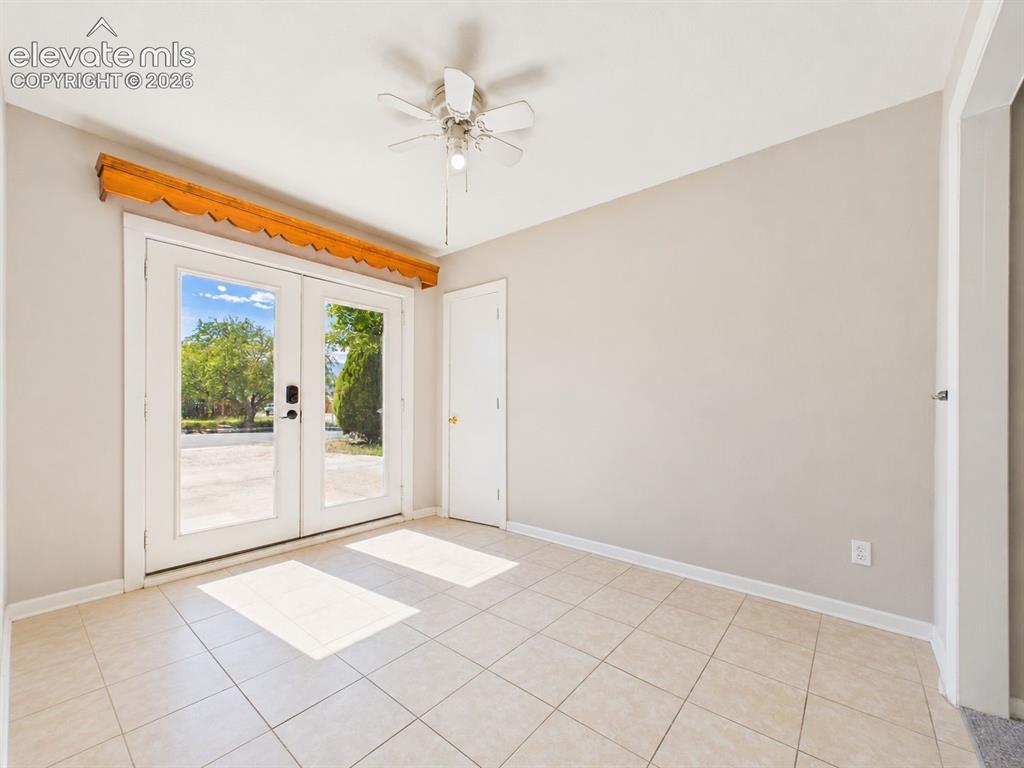 Image 36 of 50: Glass-paneled double doors bring abundant natural light into this tiled ent