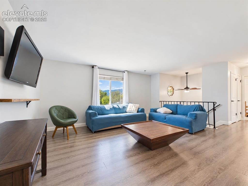 Image 4 of 50: Spacious living area with updated flooring and a large window framing a sce