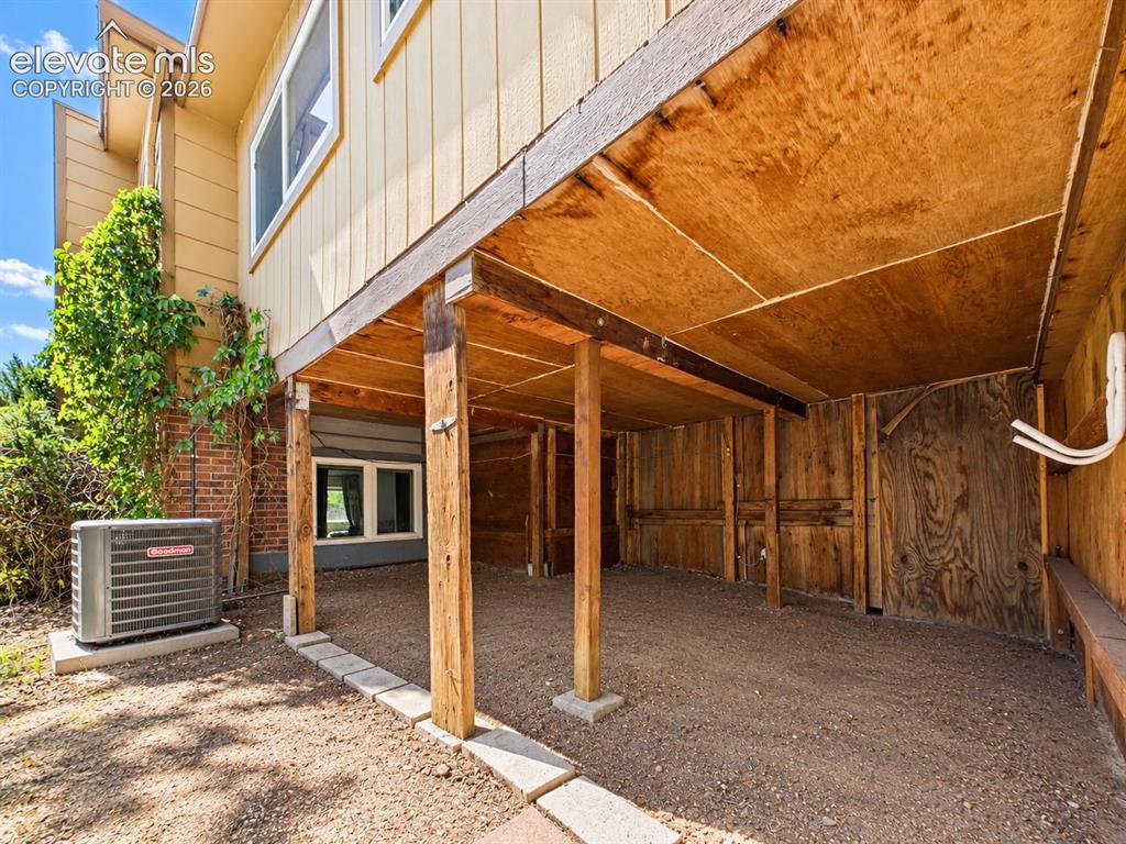 Image 45 of 50: Sheltered area beneath the elevated portion of the home provides substantia