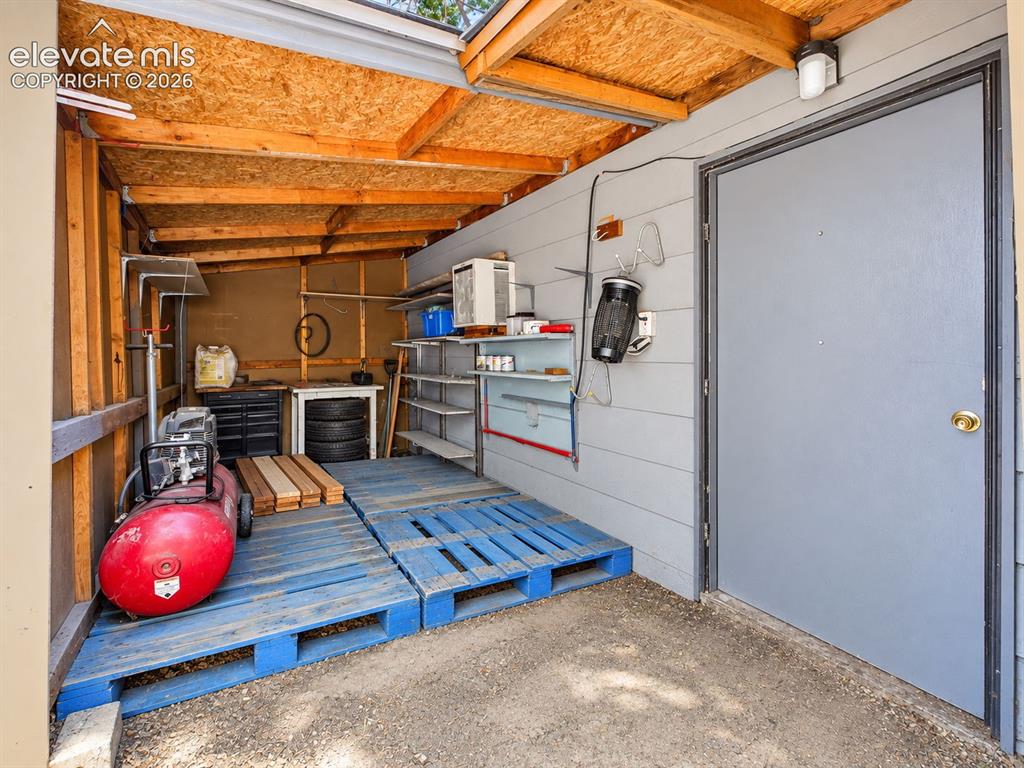 Image 46 of 50: Additional covered storage space offers shelving and room for tools, suppli