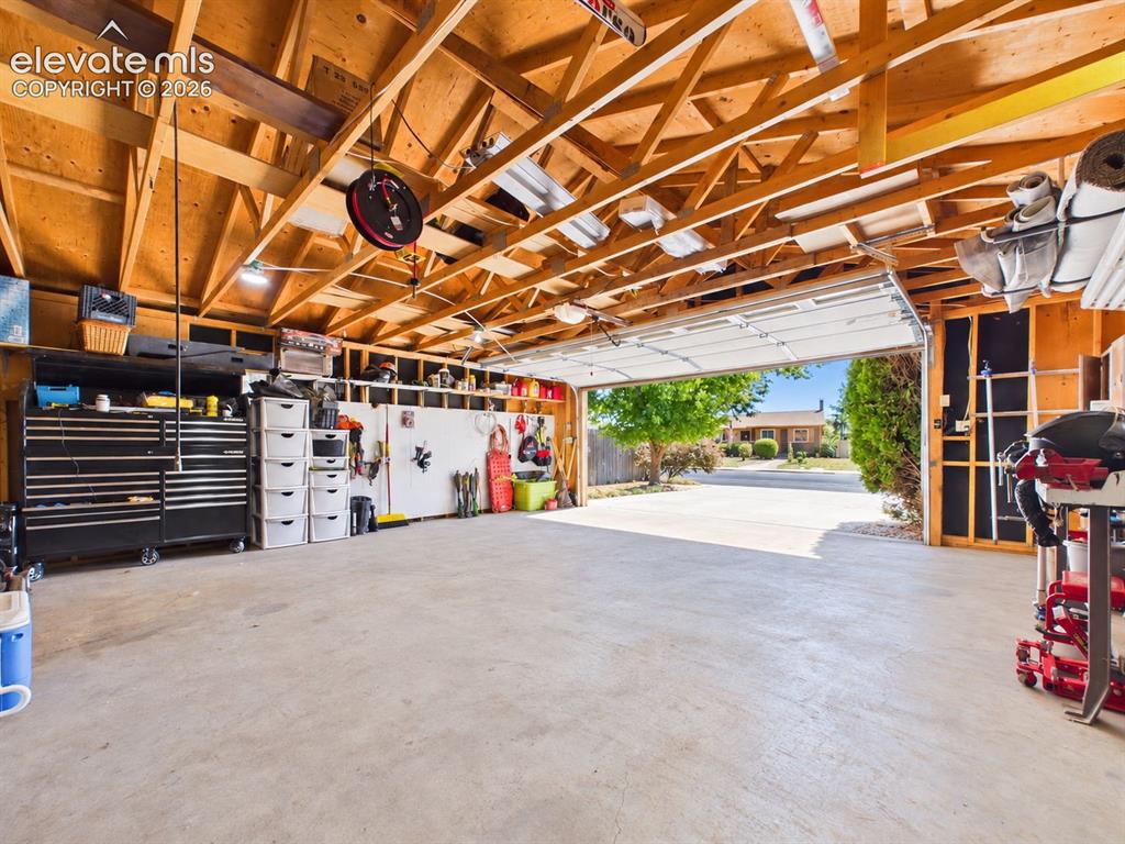 Image 48 of 50: Alternate garage view showcases the generous concrete floor area, exposed f