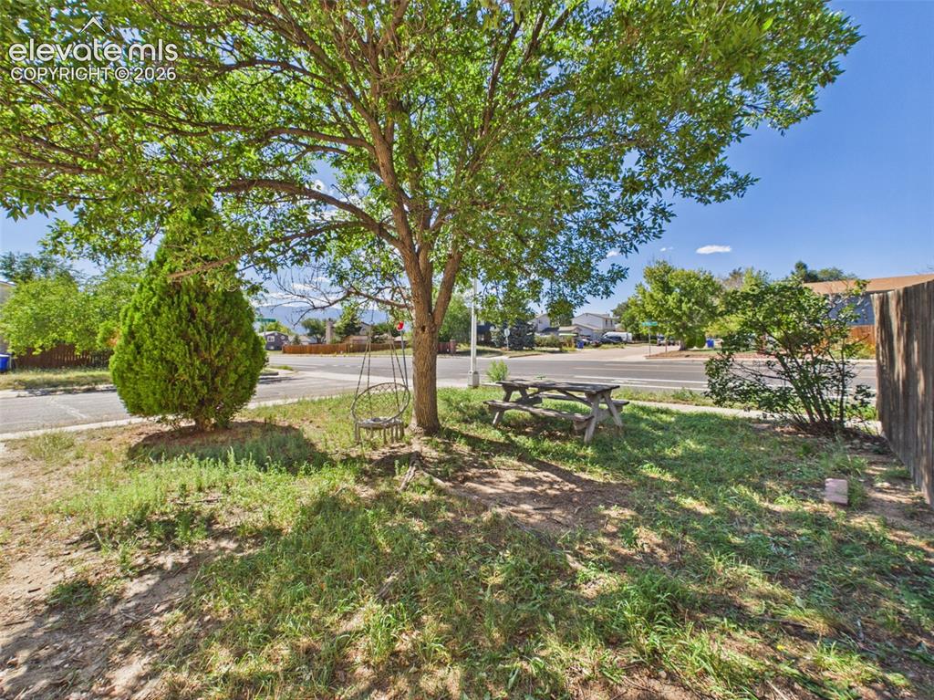 Image 49 of 50: Mature shade trees create a pleasant outdoor setting with a picnic table an