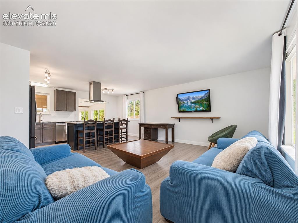 Image 6 of 50: The living room flows directly into the remodeled kitchen, creating an open