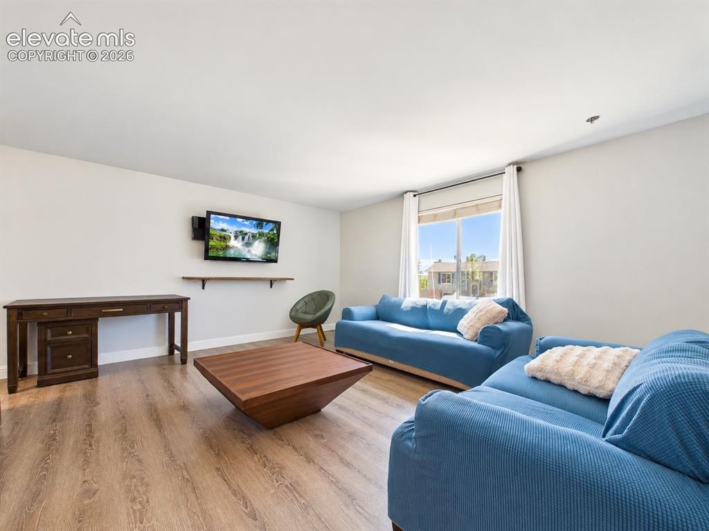 Image 7 of 50: Bright living room with updated flooring, neutral finishes, and a large vin
