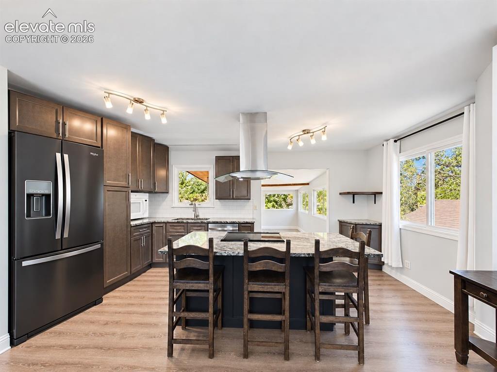 Image 8 of 50: Wide kitchen view showcasing the expansive center island, plentiful storage
