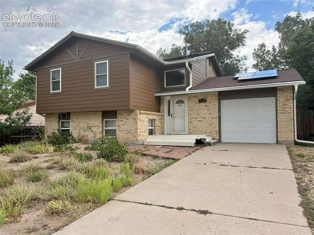 Caption: Split-level home featuring a brick and horizontal siding exterior