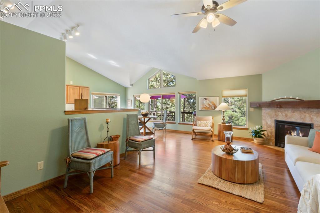Image 12 of 43: Living area featuring a ceiling fan, wood finished floors, lofted ceiling, 