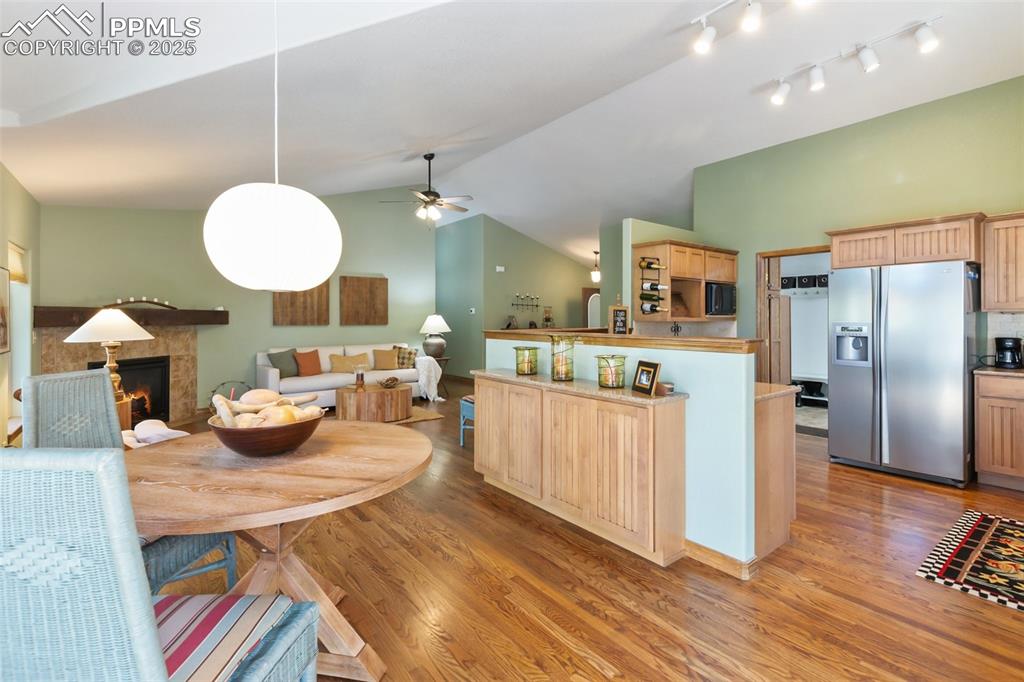 Image 15 of 43: Dining room with light wood-type flooring, ceiling fan, lofted ceiling, a t